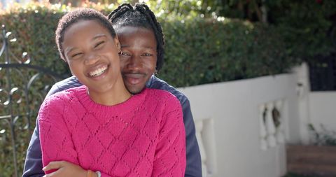 Smiling Couple Embracing in a Lush Garden Setting
