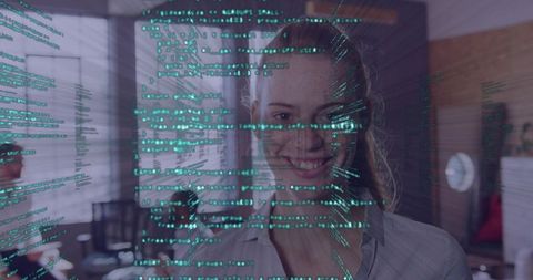 Young woman smiling behind holographic code overlay in modern office, data visualization