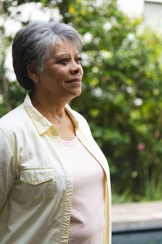 Elegant African American Senior Woman in Tranquil Garden Setting