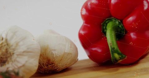 Fresh Red Bell Pepper with Garlic Bulbs in Kitchen Setting
