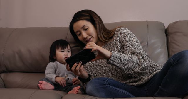 Mother and Baby Watching Mobile Phone on Couch - Download Free Stock Images Pikwizard.com