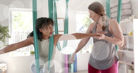 Aerial Yoga Session with Instructor Guiding Teen in Wellness Center