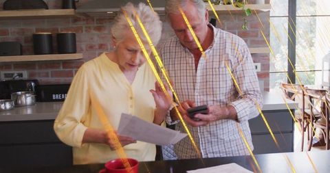 Senior Couple Reviewing Finances in Modern Kitchen Setting