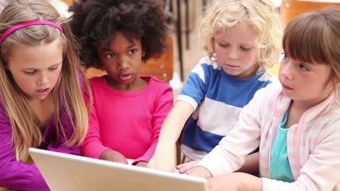 Children Collaborating on Laptop in Classroom Learning Environment