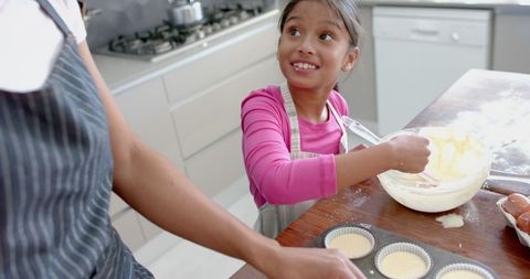 Playful Mother-Daughter Baking Session in Modern Kitchen