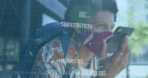 Man with mask using smartphone amid floating digital data outdoors