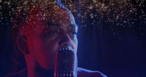 Soulful male singer on stage with sparkling lights at concert