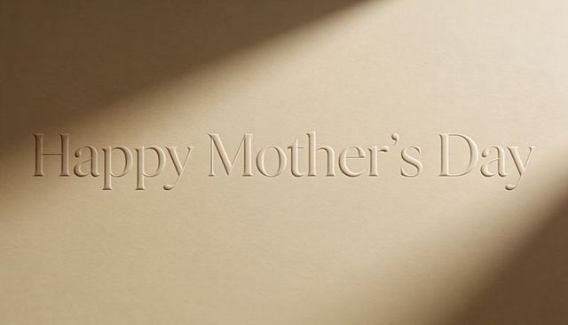 Embossed happy mother's day lettering on warm beige paper with elegant diagonal shadows