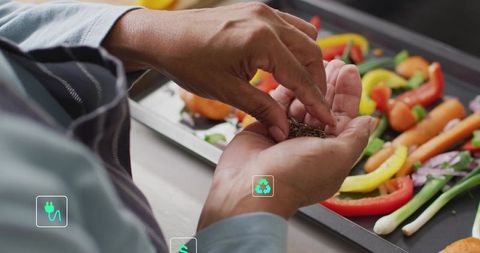 Indian cook sprinkling spices on vibrant roasted vegetables preparing healthy tray