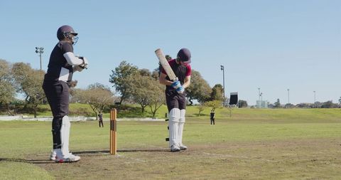 Cricket Players Practicing Batting and Wicketkeeping Outdoors