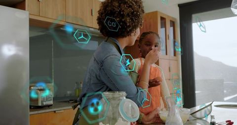 Mother feeding daughter at kitchen island with smart home icons and natural light