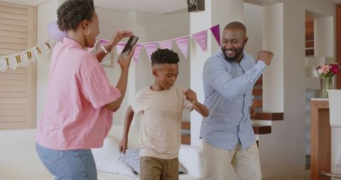 African American Family Dancing and Recording Birthday Celebration in Living Room