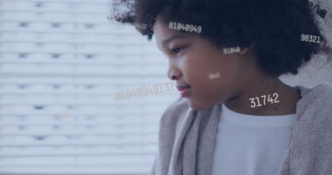 Gazing child by window with floating code overlay conveying tech future, calm contemplation
