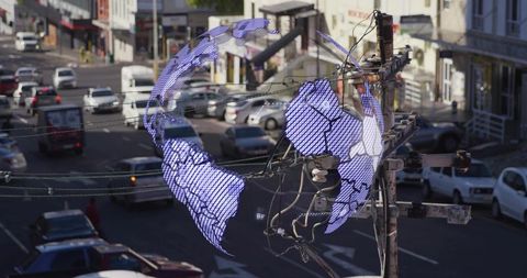 Digital globe displaying over urban utility pole with power lines and downtown traffic