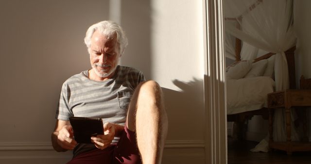 Senior Man Relaxing at Home Reading Tablet in Sunny Room - Download Free Stock Images Pikwizard.com