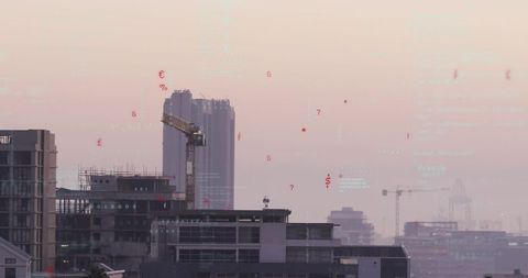 Rising highrise construction with tower crane and scaffolding over hazy urban skyline at dawn