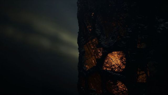 Glowing ember streaks on charred tree bark in dark forest