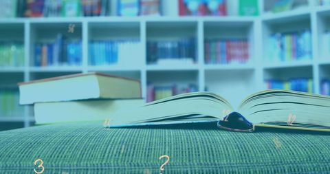 Open book in library with numbers and symbols floating overhead