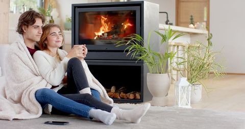 Cozy Couple Relaxing by Fireplace in Modern Living Room