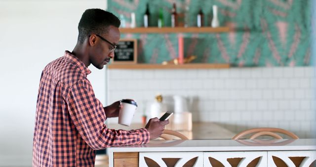 Young Professional Man Holding Coffee and Texting on Phone - Download Free Stock Images Pikwizard.com