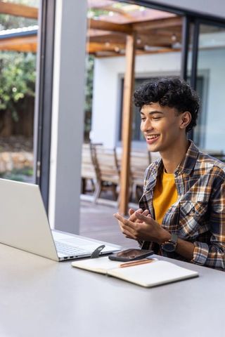 Young Asian Man Engaging in Virtual Meeting on Patio