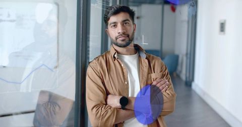 Confident professional standing in modern office with digital charts