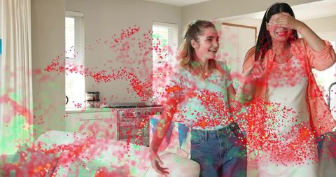 Home surprise celebration with colorful confetti burst, smiling woman and teenage girl