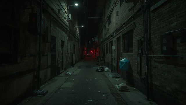 Glistening Industrial Alley at Night with Trash and Pipes