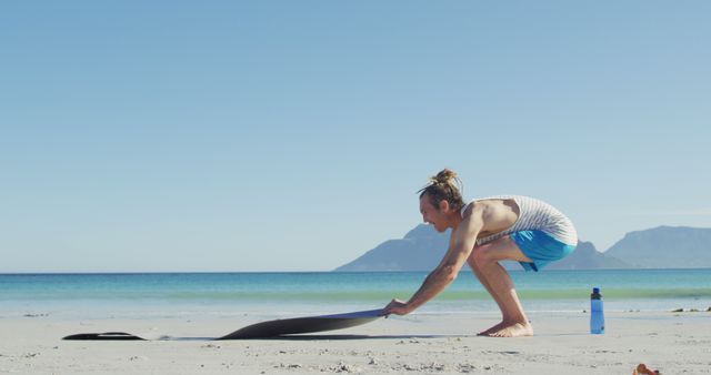 Man Preparing Yoga Mat on Beach at Sunrise - Download Free Stock Images Pikwizard.com