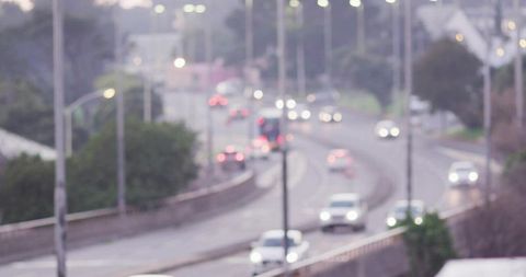 Twilight urban overpass with commuter traffic and bokeh lights on winding elevated highway