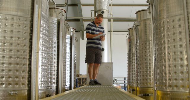 Man Inspecting Wine Fermentation Tanks in Modern Winery - Download Free Stock Images Pikwizard.com