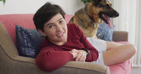 Woman relaxing on sofa with loyal german shepherd