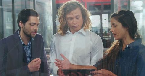 Diverse Colleagues Discussing Analytics on Digital Tablet in Collaborative Office