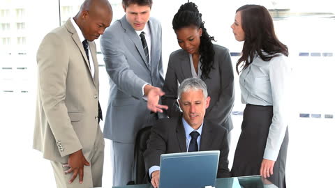 Group of Diverse Professionals Collaborating Around Laptop