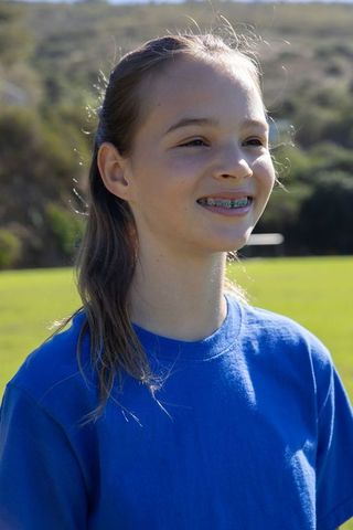 Teenage Girl with Braces Smiling in Sunlit Field