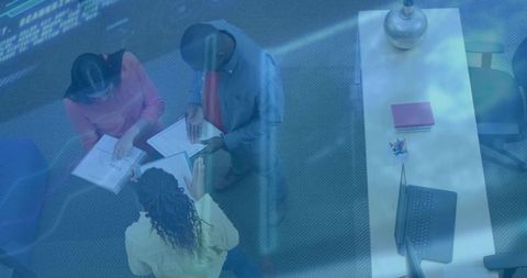 Group of colleagues collaborating over documents in modern office
