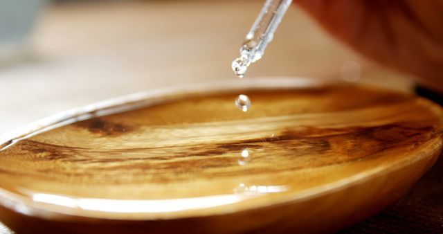 Drop of water dropped from pipette on brown wooden counter - Download Free Stock Photos Pikwizard.com