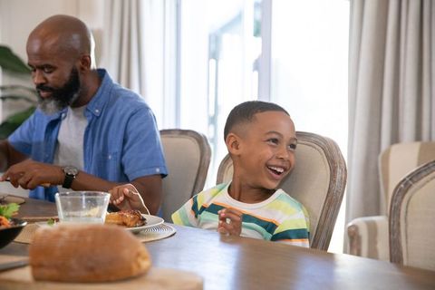 Joyful Family Meal with Smiling Father and Son at Dining Table