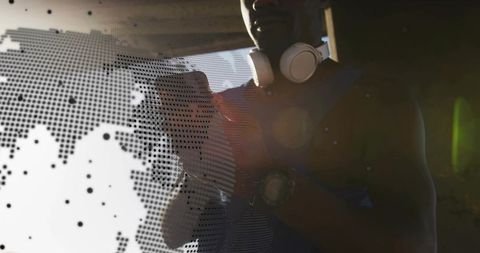 Athlete adjusting crossbody and watch wearing headphones with halftone world map overlay