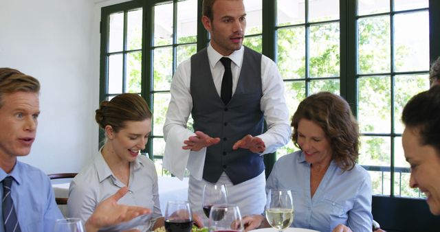 Waiter Serving Food to Enthusiastic Group of Diners in Restaurant - Download Free Stock Images Pikwizard.com