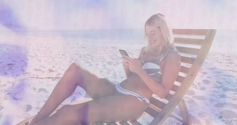 Woman Enjoying Leisure Time on Sunny Beach with Smartphone