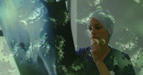 Healthcare worker analyzing x-ray with virus visualization overlay