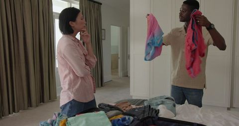 Couple Collaborating on Packing in Relaxed Bedroom Setting