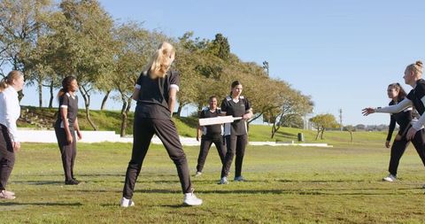 Diverse female cricket team bonding in outdoor practice