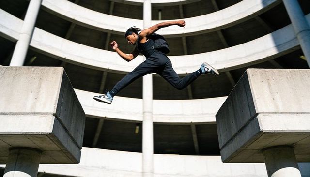 Urban parkour athlete leaping between concrete pillars with dynamic architectural lines
