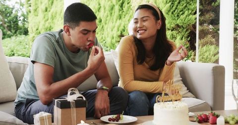 Couple Enjoying Outdoor Birthday Celebration with Cake and Fruits