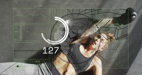 Breathing woman lying on gym mat with biometric hud overlay and punching bag nearby