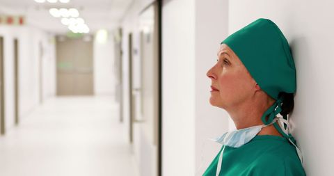 Thoughtful Female Surgeon in Hospital Corridor