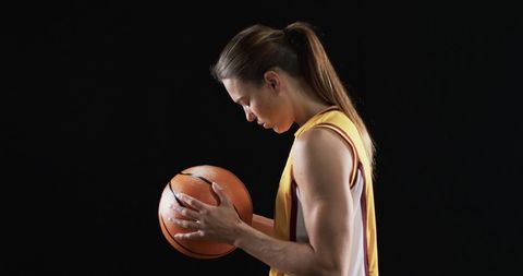 Determined Female Basketball Player Gripping Ball in Dark Atmosphere - Download Free Stock Images Pikwizard.com