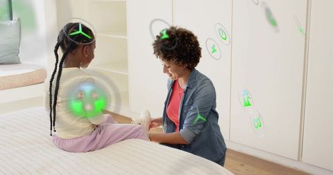 Kneeling caregiver fastening child's sneaker with green augmented reality eco icons